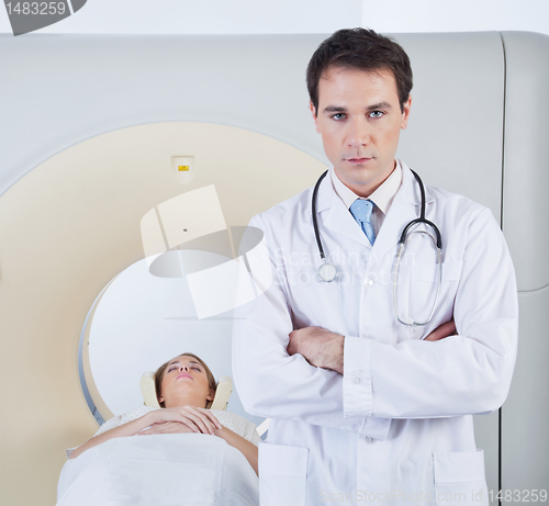 Image of Doctor standing in front of CT scan machine