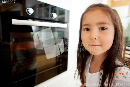 Image of Young Girl Watching Cookies Bake