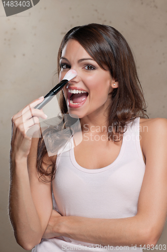 Image of Woman applying blusher on nose