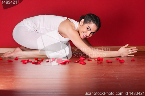 Image of Young female doing yoga in a child pose