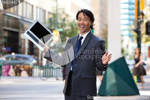 Image of Businessman holding laptop and laughing