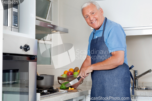 Image of Man Cutting Vegetables At Kitchen Counter
