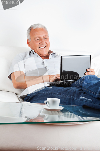 Image of Relaxed Senior Man Working on Laptop