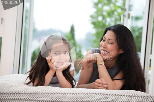Image of Mother and daughter on couch laughing