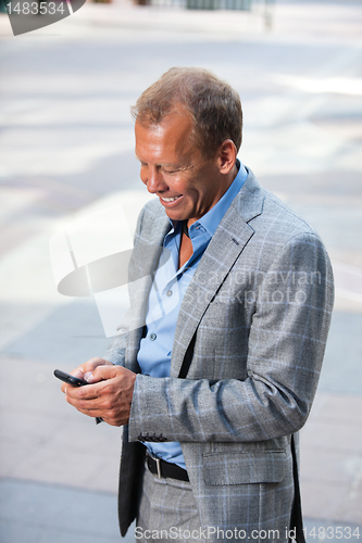 Image of Portrait of businessman text messaging