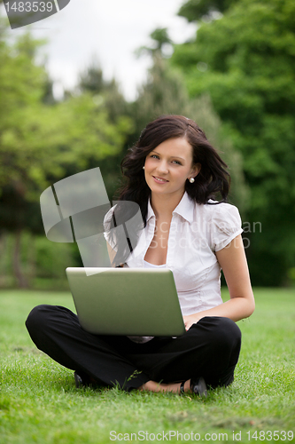 Image of Female Sitting on Grass Using Laptop