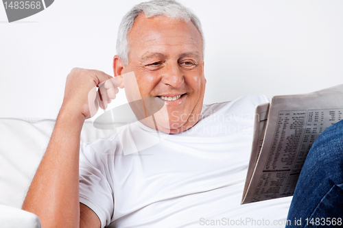 Image of Senior Man Reading Newspaper At Home