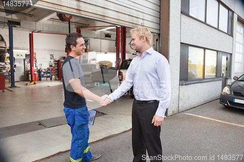 Image of Mechanic shaking hands with client