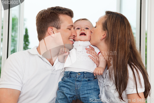 Image of Parents kissing child