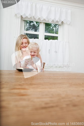 Image of Mother with baby boy looking at bread