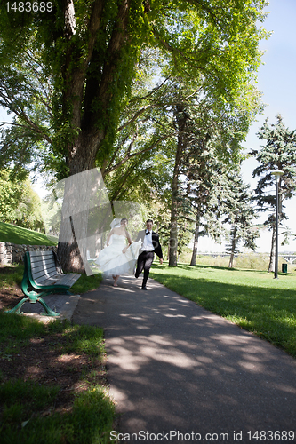 Image of Newlywed Running Along Walkway