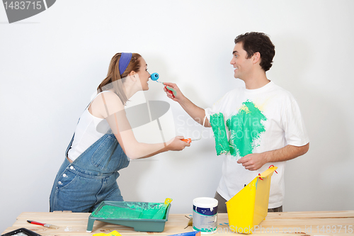 Image of Playful couple playing with paint