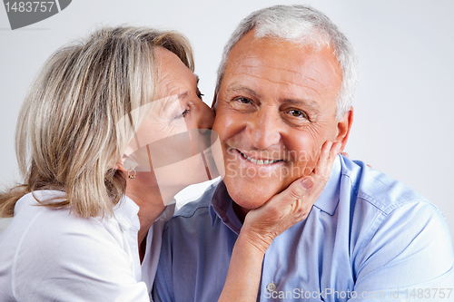 Image of Senior Man Being Kissed By His Wife