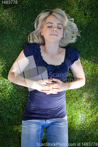 Image of Young woman lying on grass