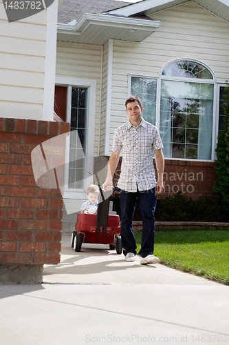 Image of Father Pulling Son Sitting in Pram