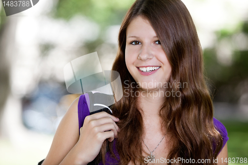 Image of Cute teenage girl holding backpack