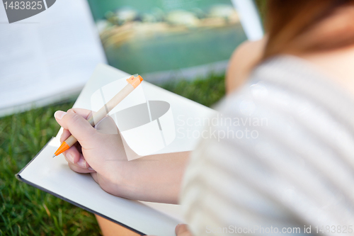 Image of Girl writing in a notebook