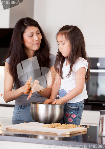 Image of Mother with Young Daughter Baking Cookies