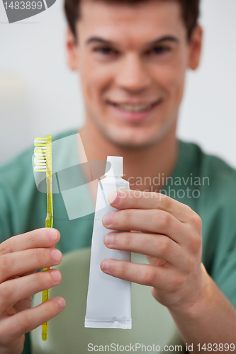Image of Dentist holding toothpaste and toothbrush