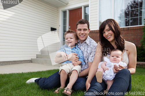Image of Couple Sitting on Grass With Their Children