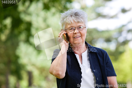 Image of Senior woman having conversation on mobile phone