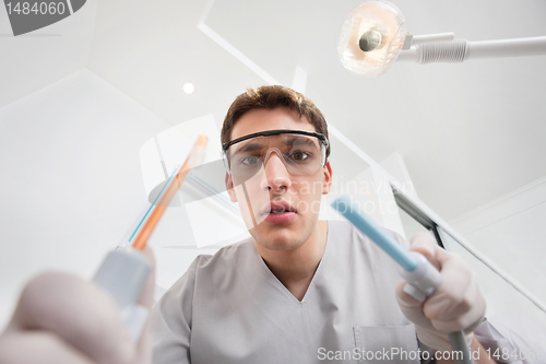 Image of Young male holding dental tools