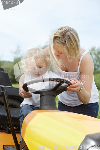 Image of Young Boy with Mother on Garden Tractor