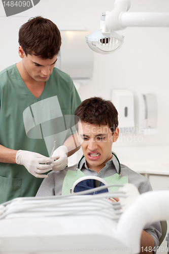 Image of Dentist with Patient Looking at Teeth