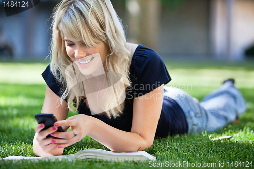 Image of Happy young girl using cell phone