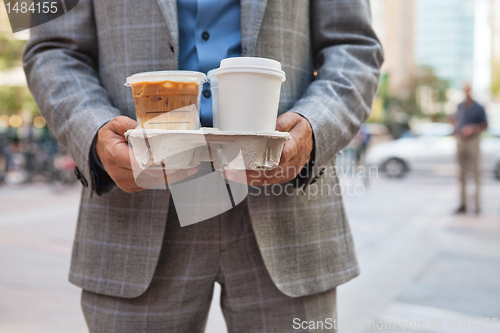 Image of Businessman holding takeaway coffee cups