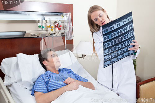 Image of Doctor and patient examining X-ray report