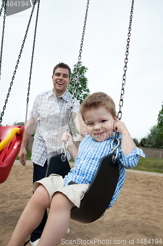 Image of Father Pushing Son on Swing