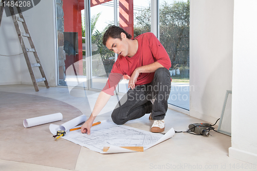 Image of Young architect analyzing blueprint