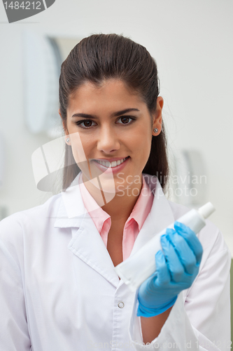 Image of Female dentist holding toothpaste