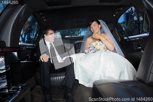 Image of Newly wed couple in limousine