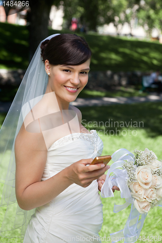 Image of Newlywed Bride Holding Cell Phone