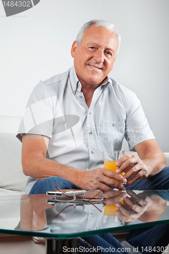 Image of Senior Man Holding Glass of Orange Juice