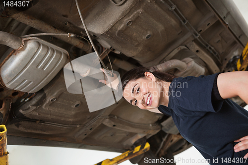 Image of Smiling Female Mechanic Under Car