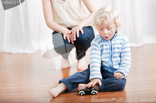 Image of Cute boy playing with toy car