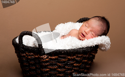 Image of Cute baby asleep in basket