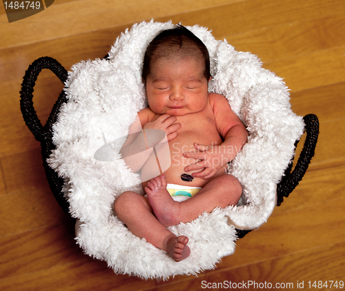 Image of Cute baby asleep in basket