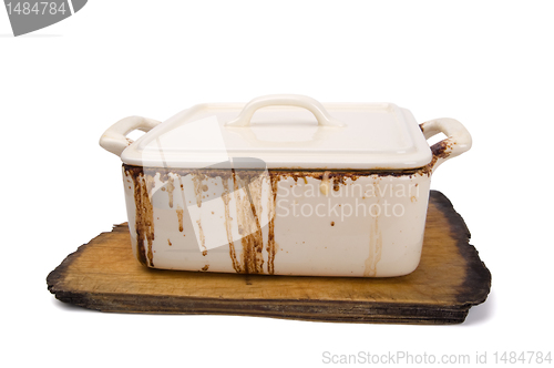 Image of Dirty ceramic pot for stove on old kitchen board