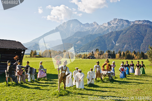 Image of Group of scarecrows in female dress standing on a field