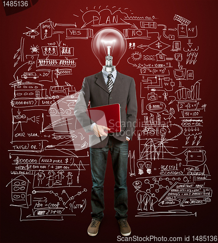 Image of male in suit with lamp and laptop in his hands