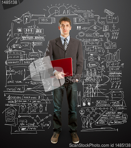 Image of male in suit with laptop in his hands