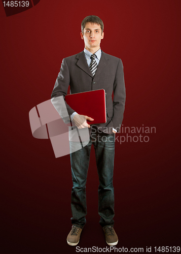 Image of male in suit with laptop in his hands