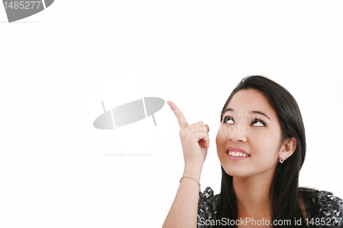 Image of Attractive young woman points to something above her head 