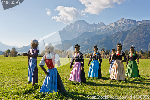Image of Group of scarecrows in female dress standing on a field