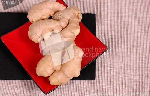 Image of Hand of ginger on red plate and black napkin