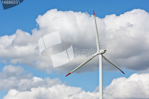 Image of Wind power station against the blue sky with clouds